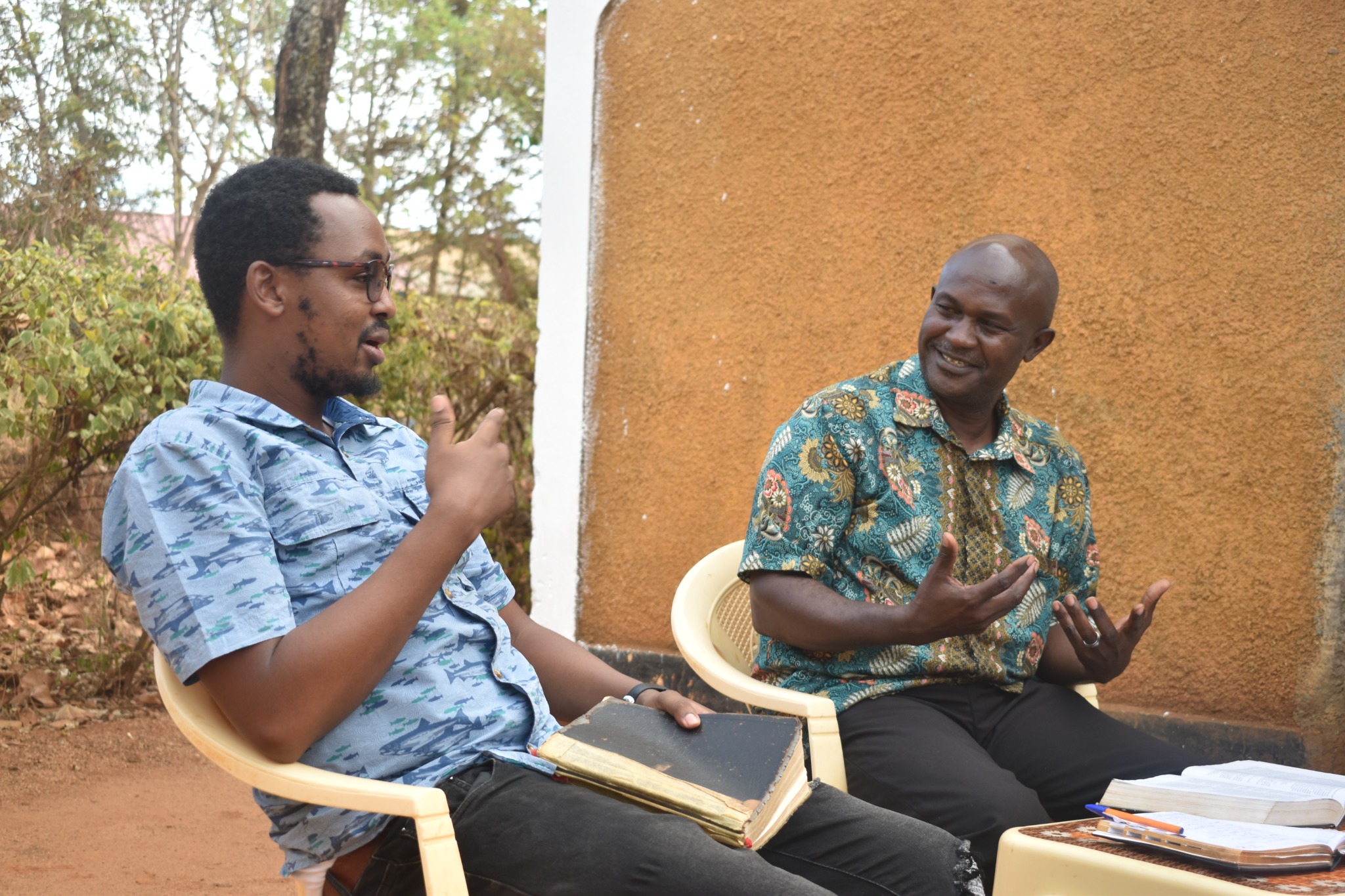 Two men in conversation with Bibles