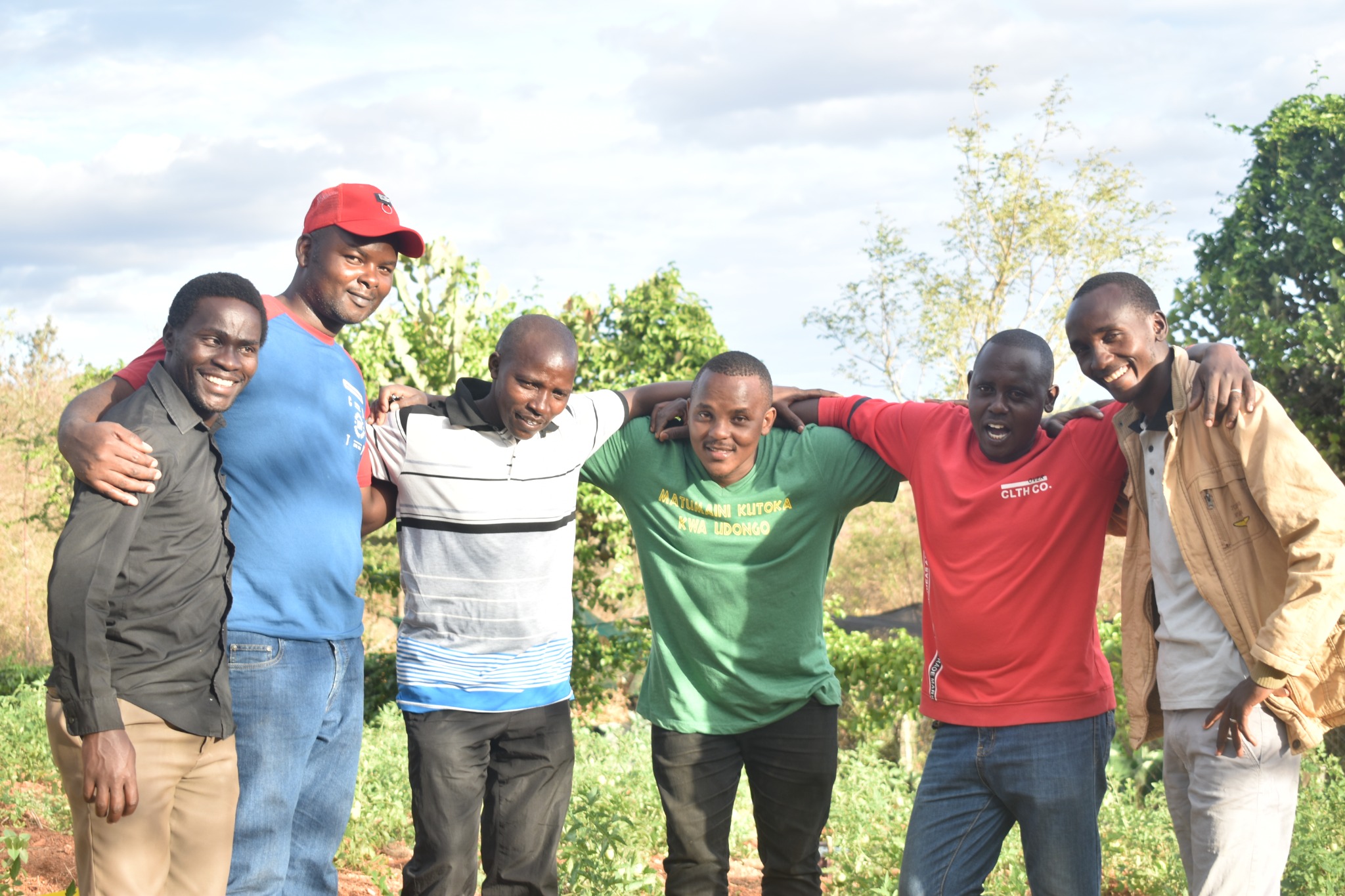 Group of six people smiling outdoors