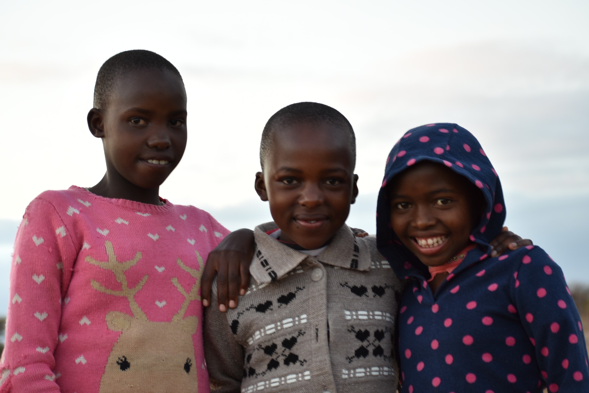 Three children smiling together